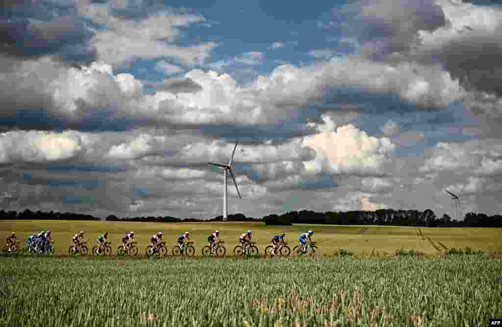 The pack of riders cycles past fields during the 3rd stage of the 109th edition of the Tour de France cycling race, 182 km between Vejle and Sonderborg in Denmark.