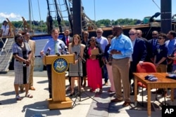 康涅狄格州长拉曼特在康州新伦敦一艘复制的“阿米斯塔德”号运奴船前举行的仪式上签署将6月19日六月节定为州假日的法案。(2022年6月10日)