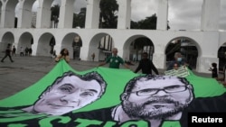Demonstran memegang spanduk dengan gambar jurnalis Inggris Dom Phillips dan spesialis urusan Pribumi Brasil Bruno Pereira, keduanya terbunuh di Amazon, selama protes di Arcos da Lapa (Lapa Arches) di Rio de Janeiro, Brazil. (Foto : REUTERS/Pilar Olivares