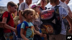 Вынужденные переселенцы на станции Покровска садятся на поезд, направляющйся в Днепр, Донецкая область Украины, 8 июля 2022 г. (фото AP Photo/Nariman El-Mofty)