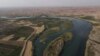 This picture taken on June 12, 2022 shows an aerial view of the Tigris river which is witnessing lower levels of water due to climate change and repeated heatwaves. at Hammam al-Alil, south of Iraq's northern city of Mosul. 