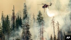 Un hélicoptère largue de l'eau sur l'incendie qui brûle dans le parc national de Yosemite, le 9 juillet 2022.