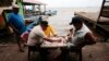 Pescadores juegan tablero -similar a las damas- en el puerto antes de la llegada de la tormenta tropical Bonnie en Bluefields, Nicaragua.&nbsp;