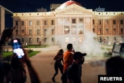 Arizona state troopers deploy tear gas as they confront abortion rights protesters during a protest at the Arizona Capitol, following the U.S. Supreme Court ruling to overturn abortion rights established under Roe v. Wade, Phoenix, Arizona, June 24, 2022.