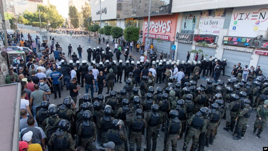 Polisi anti huru hara dan petugas keamanan Palestina bentrok dengan demonstran setelah unjuk rasa memprotes kematian kritikus vokal Otoritas Palestina Nizar Banat, di kota Ramallah, Tepi Barat, Sabtu, 26 Juni 2021. (AP Photo/Nasser Nasser, File)