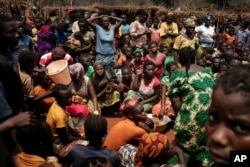 FILE - Displaced people who fled Bangassou wait for food distribution in the village where they found refuge, Siwa, Central African Republic, Feb. 13, 2021.