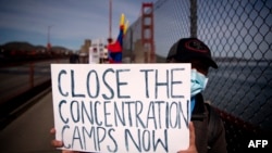 A protester holds up a "Close The Concentration Camps Now" sign after marching across the Golden Gate Bridge during a demonstration against the 2022 Beijing Winter Olympic Games, in San Francisco, California on Feb. 3, 2022.