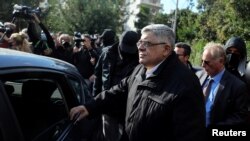 FILE - Leader of the far-right Golden Dawn party Nikos Mihaloliakos is escorted as he leaves his home, after the party was declared a criminal organization by a court in Athens, Greece, Oct. 22, 2020.