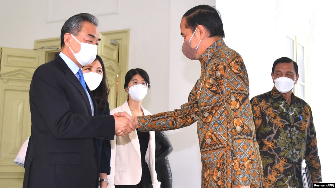 Presiden Jokowi berjabat tangan dengan Menteri Luar Negeri China Wang Yi di Istana Merdeka, Jakarta, 11 Juli 2022. (Foto: AFP/Rusman)