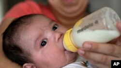 Yury Navas alimenta con leche de fórmula a su bebé José Ismael Gálvez, de dos meses, en su apartamento en Laurel, Maryland, el 23 de mayo de 2022.