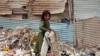 Seorang anak pengungsi asal Afghanistan tampak memilah milih sampah untuk mencari barang yang dapat didaur ulang agar ia dan keluarganya dapat bertahan hidup selama berada di Karachi, Pakistan. Foto diambil pada 19 Juni 2022. (Foto: AP/Fareed Khan) 