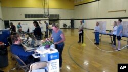 Washoe County voters line up inside a gymnasium at Reed High School in Sparks, Nev. on June 14, 2022, to cast their primary election ballots.