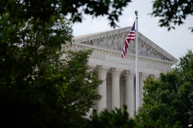 FILE - An American flag waves in front of the U.S. Supreme Court building, Monday, June 27, 2022, in Washington. (AP Photo/Patrick Semansky)