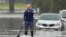 A man paddles on a stand-up paddle board through a flooded street at Windsor on the outskirts of Sydney, Australia, on July 5, 2022. Hundreds of homes have been inundated in and around Australia's largest city in a flood emergency that was impacting 50,000 residents in Sydney.