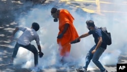 Protesters react after police fired tear gas to disperse them in Colombo, Sri Lanka, July 9, 2022.