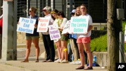 Members of the Dayspring Community Church youth group of Clinton, Miss., stand outside the Jackson Women's Health Organization clinic in Jackson, holding signs opposing abortion, June 15, 2022.