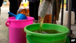 Ilustrasi - Petugas mengisi ember dengan minyak goreng curah yang disediakan oleh Badan Urusan Logistik (BULOG) dengan harga diskon, di titik distribusi di Jakarta, 20 Mei 2022. (AP Photo/Dita Alangkara)