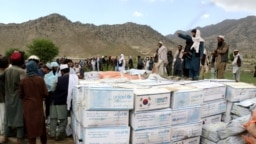 Afghan men gather to collect relief goods after a recent earthquake in Gayan, Afghanistan, June 23, 2022. 