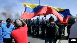 Policías antidisturbios enfrentan a manifestantes en la "Ruta Viva", una de las vías hacia el aeropuerto internacional de Quito, Ecuador, en el marco de protestas indígenas para pedir la reducción del precio del combustible, el 17 de junio de 2022.