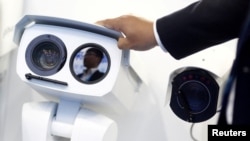 ກ້ອງ CCTV ຢູ່ເທິງຊັ້ນວາງຂາຍຜະລິດຕະພັນກ້ອງວົງຈອນປິດ ຂອງດາຮົວ ເທັກໂນໂລຈີ (Dahua Technology) ທີ່ງານສະແດງສິນຄ້າປັກກິ່ງ ປະເທດຈີນ 2018, ທີ່ ປັກກິ່ງ, ເມື່ອວັນທີ 23 ຕຸລາ 2018. ລັດຖະບານທະຫານຂອງມຽນມາ ກໍາລັງຕິດຕັ້ງກ້ອງວົງຈອນປິດທີ່ມີຄວາມສາມາດຈື່ໜ້າຂອງຄົນໄດ້ໃນຫຼາຍໆເມືອງຂອງປະເທດ.