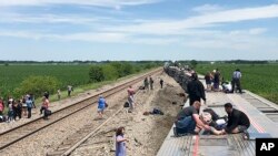 En esta foto proporcionada por Dax McDonald, un tren de pasajeros de Amtrak yace de costado después de descarrilarse cerca de Mendon, Missouri, el 27 de junio de 2022.