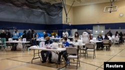 FILE - Health care workers prepare to distribute doses of the Pfizer-BioNTech vaccine against the coronavirus disease (COVID-19) at a booster clinic in Lansdale, Pennsylvania, Jan. 9, 2022.