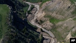 Las aguas de inundación que retroceden fluyen más allá de las secciones de North Entrance Road arrastradas por el agua en el Parque Nacional Yellowstone en Gardiner, Mont., 16 de junio de 2022.