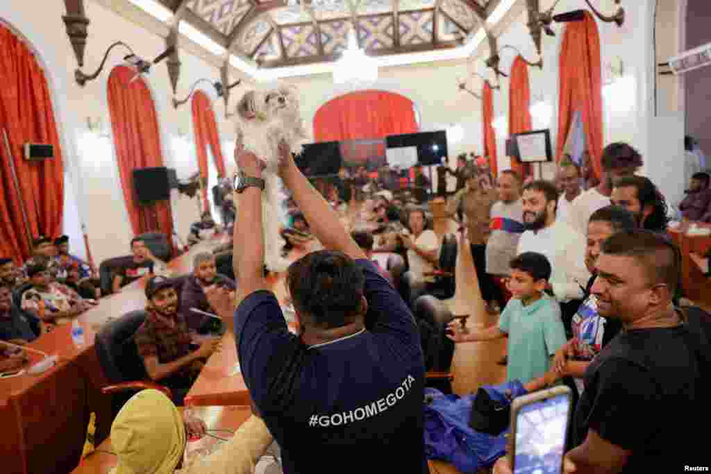 A demonstrator shows a dog as the new &quot;Wildlife Minister&quot; at the President Gotabaya Rajapaksa&#39;s cabinet meeting room at the President&#39;s house in Colombo, Sri Lanka, on the following day after demonstrators entered the building, amid the country&#39;s economic crisis.