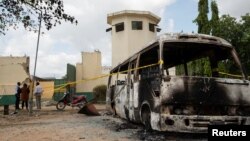 FILE - A burned vehicle stands in front of the entrance of the medium-security prison after the attack by several gunmen in Kuje, near Abuja, Nigeria July 6, 2022.