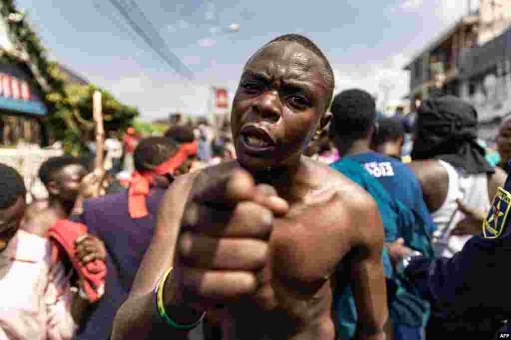 A demonstrator motions with his hand as he and others try to reach the border between Democratic Republic of Congo and Rwanda during a protest in Goma.