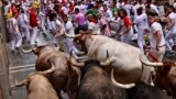 FILE - People run through the streets at the San Fermin Festival in Pamplona, northern Spain, July 7, 2022. Imagine these bulls running through in a small china shop. (AP Photo/Alvaro Barrientos)