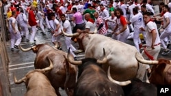 FILE - People run through the streets at the San Fermin Festival in Pamplona, northern Spain, July 7, 2022. Imagine these bulls running through in a small china shop. (AP Photo/Alvaro Barrientos)