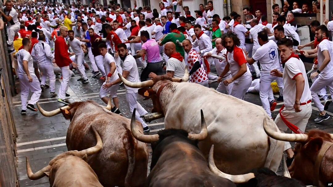 Orang-orang berlarian di jalanan pada hari pertama adu banteng dan sapi jantan di Festival San Fermin, Pamplona, Spanyol utara, Kamis, 7 Juli 2022. (AP/Alvaro Barrientos)