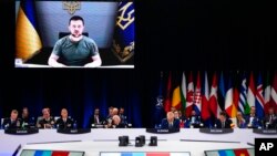 Ukraine's President Volodymyr Zelenskyy addresses leaders via a video screen during a roundtable meeting at a NATO summit in Madrid, Spain, June 29, 2022.