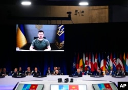 Ukraine's President Volodymyr Zelenskyy addresses leaders via a video screen during a roundtable meeting at a NATO summit in Madrid, Spain, June 29, 2022.