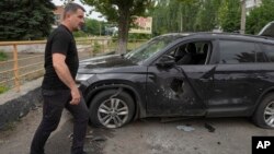 Slovyansk Mayor Vadym Lyakh passes by a car damaged by the Russian shelling in the city centre, in Slovyansk, Donetsk region, Ukraine, June 30, 2022. 