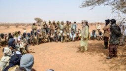 Des militants du Mouvement pour le salut de l'Azawad écoutent des instructions à un point de cheminement tout en patrouillant le long de la frontière Mali-Niger dans la zone déserte de la région de Meneka au Mali lors d'une patrouille anti-djihadiste le 5