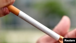 A woman lights a cigarette in a park in Brussels, May 7, 2017. The U.S. Food and Drug Administration is proposing to limit the amount of nicotine allowed in cigarettes with an aim to make it easier for people to quit using them and prevent young people fr