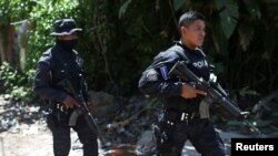 Policías patrullan la zona donde tres policías fueron asesinados por presuntos pandilleros durante un patrullaje en el barrio La Realidad, en Santa Ana, El Salvador, el 29 de junio de 2022.