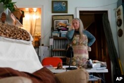FILE - FILE - Nancy Rose, who contracted COVID-19 in 2021 and continues to exhibit long-haul symptoms, pauses while organizing her desk space, Jan. 25, 2022, in Port Jefferson, N.Y. Rose, 67, reported bouts of fatigue, brain fog and memory loss.