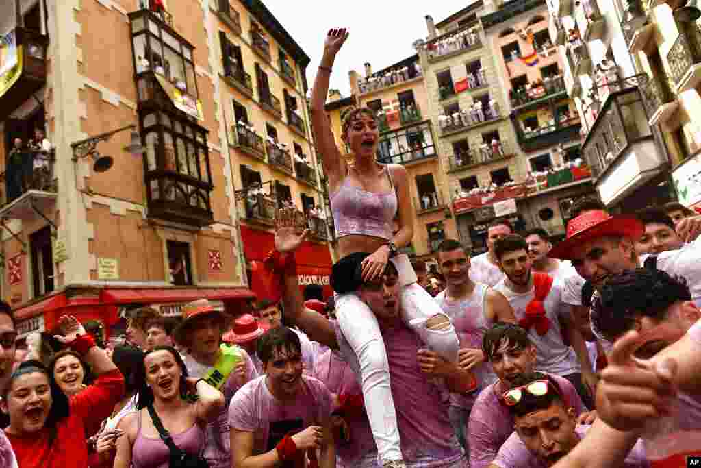 People celebrate while waiting for the launch of the Chupinazo rocket, to mark the official opening of the 2022 San Fermin fiestas in Pamplona, Spain.