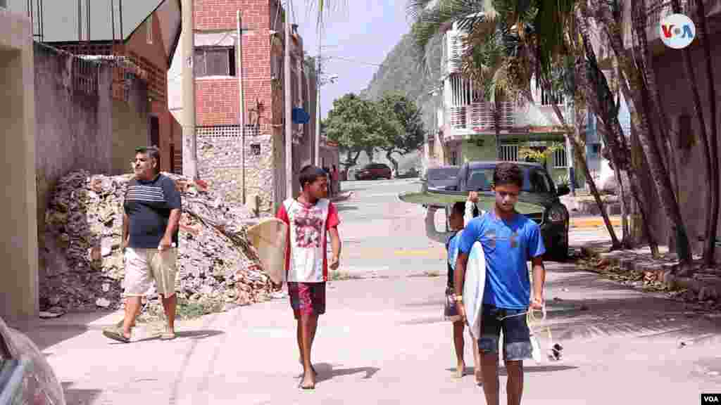 Yandel Merentes, con camiseta azul, lidera un grupo de niños en Anare, en la costa Caribe de Venezuela, que han hecho del surf una pasión de su vida. [Foto: VOA / Nicole Kolster].