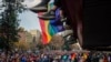 Los pies de los adolescentes cuelgan de un balcón mientras ven pasar el desfile anual del Orgullo Gay en Santiago, Chile, el 25 de junio de 2022. 