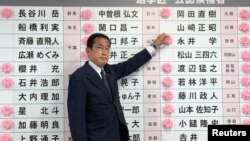 일본 참의원 선거가 실시된 지난 10일 자유민주당 총재인 기시다 후미오 총리가 도쿄 당사에서 당선인 이름에 꽃을 달아주고 있다.