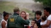 Un agente de la Patrulla Fronteriza de Estados Unidos conversa con un grupo de migrantes el 22 de mayo en el paso del Río Grande en Texas. EEUU ha expulsado del territorio más de 1.9 millones de veces a migrantes irregulares bajo la regla del Título 42. (Foto AP / Archivo)