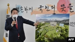 FILE - South Korea's president-elect Yoon Suk-yeol shows a bird's eye view of his planned relocation of the presidential office during a press conference at his transition team office in Seoul on March 20, 2022. 