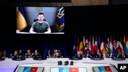 FILE: Ukraine's President Volodymyr Zelenskyy addresses leaders via a video screen during a round table meeting at a NATO summit in Madrid, Spain, 6.29.2022. On the next day, U.S. President Biden announced additional weapons and military assistance. 
