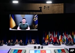 Ukraine's President Volodymyr Zelenskyy addresses leaders via a video screen during a round table meeting at a NATO summit in Madrid, Spain, June 29, 2022.