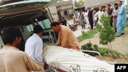 People carry the dead body of a passenger on a stretcher, who died in a bus accident, outside a hospital in Zhob district of Balochistan province on July 3, 2022
