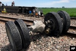 In this photo provided by Dax McDonald, debris sits near railroad tracks after an Amtrak passenger train derailed near Mendon, Mo., June 27, 2022.